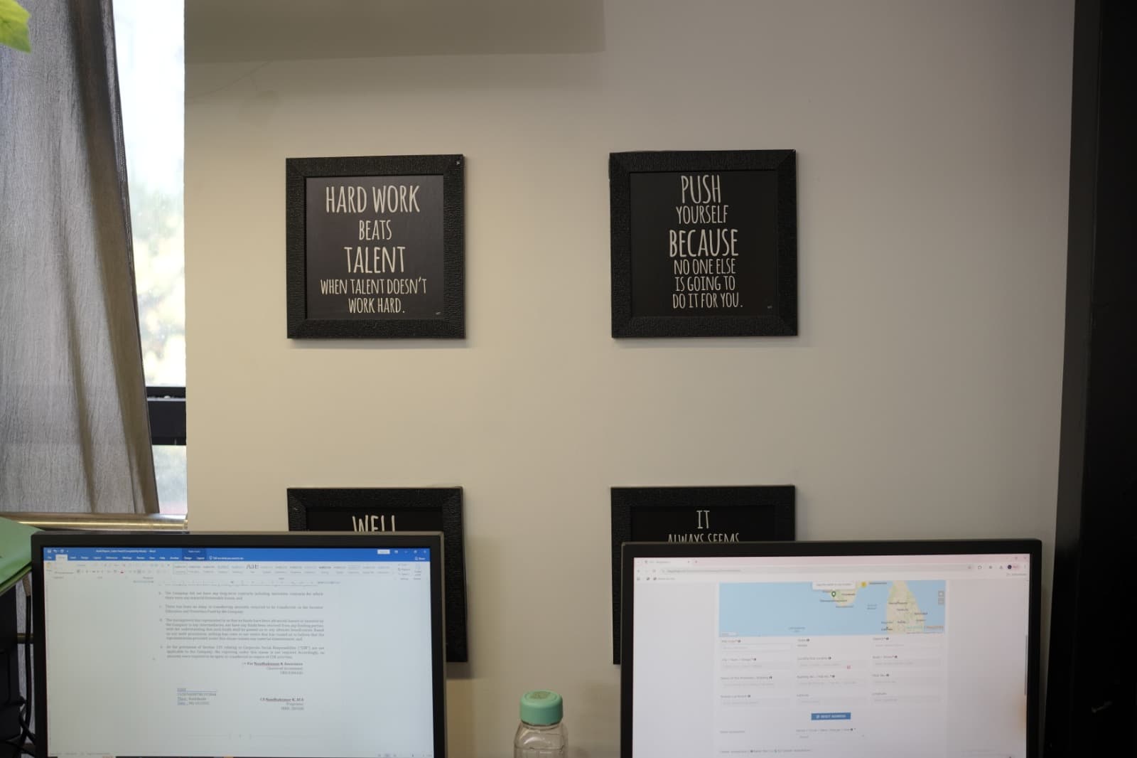 Pelago workspace with compliance documents on screen and motivational quote frames on the wall